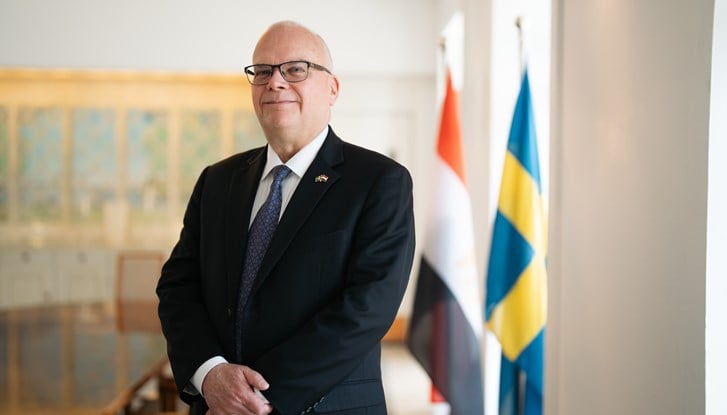 Photo of Ambassador Dag Juhlin-Dannfelt at the Swedish Residence in Cairo, Egypt, with the Swedish and Egyptian Flags side to side in the background.