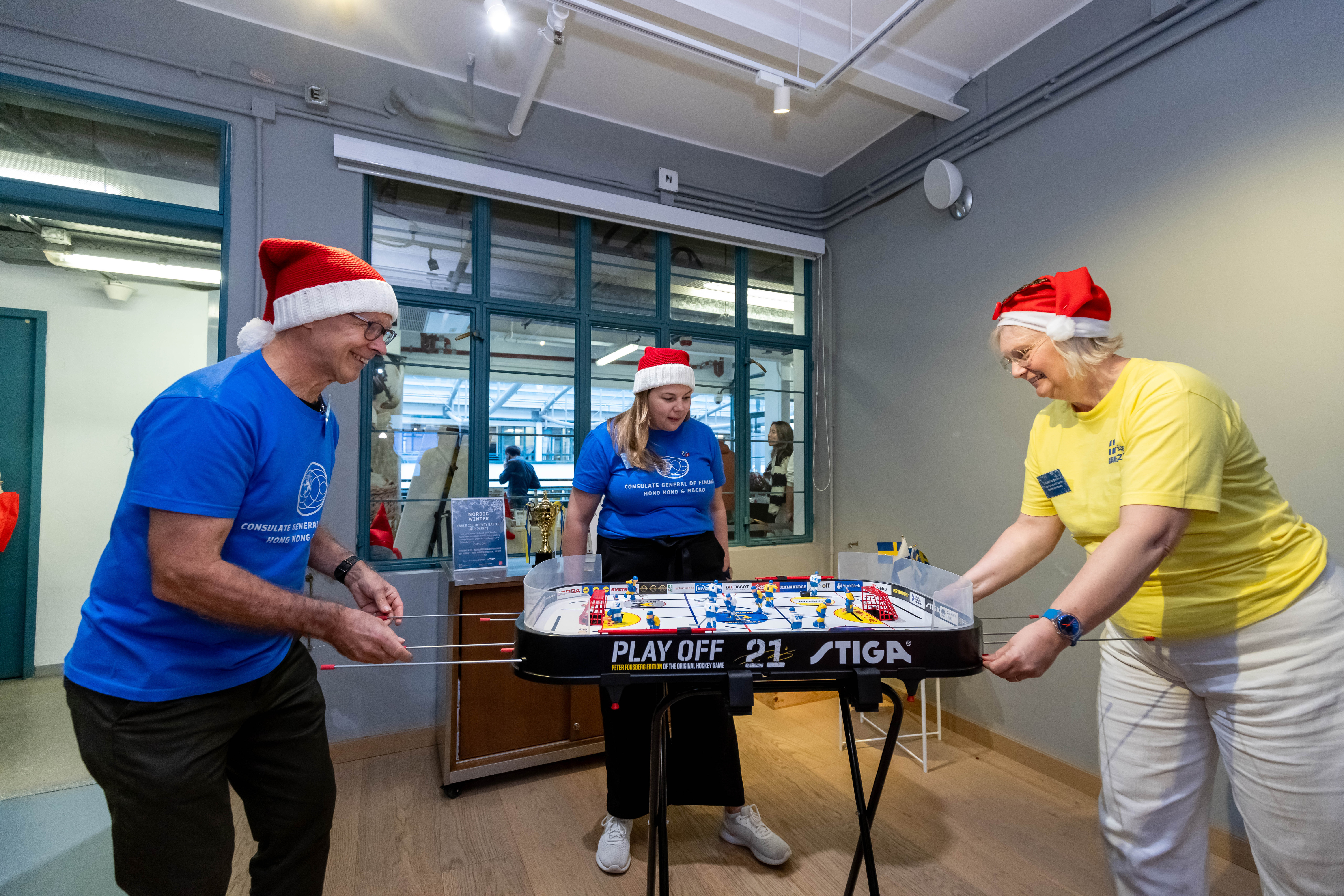 Timo Kantola, Finnish Consul General in Hong Kong (left), and Louise Bergholm, Swedish Consul General in Hong Kong (right), play a table ice hockey match at the event.